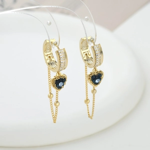 Detail of gold heart earrings with micro-set blue zircons and delicate chain tassels