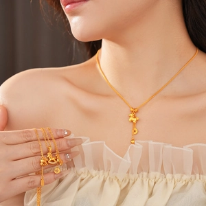 Close-up of a gold-plated horse and coin pendant necklace and bracelet set on model