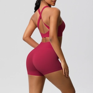Detailansicht des tiefroten Yoga-Sets mit überkreuztem BH und High-Waist-Shorts am Rücken