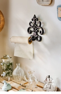 Macro detail of vintage cast iron toilet paper holder with fleur-de-lis relief pattern