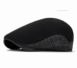 Detail of wool blend newsboy hat featuring classic black and grey plaid textured fabric