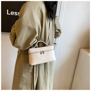 Close-up of white lychee pattern leather handbag with top handle and double zippers