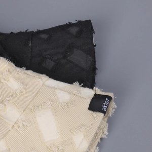 Vue macro du tissu en toile avec découpes carrées et étiquette tissée alder