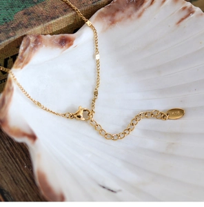 Macro view of 18K gold plated lobster clasp and K18 hallmark on the necklace chain