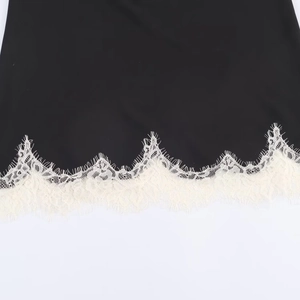 Women's black satin camisole top featuring intricate cream lace trim at the hemline