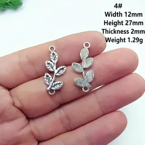 Macro detail of 12x27mm silver alloy leaf charms with texture and precise dimensions