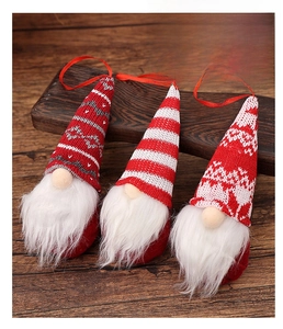 Three Christmas gnomes with knitted hats and white beards on a rustic wooden surface