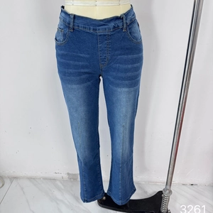 Detail view of high waist denim jeans with vertical stitching and distressed whiskering