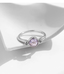 Macro detail of S925 sterling silver ring with purple crystal and bezel set round cubic zirconia