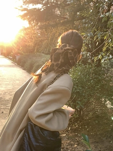 Close-up of a large leopard print fabric scrunchie in sunset outdoor lighting