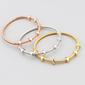 Detailed view of nut and bolt style metal bangles in rose gold, silver, and gold finishes