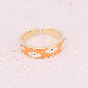Macro detail of gold Evil Eye open ring with orange enamel and micro-set zircon