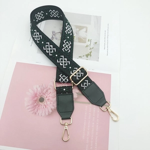 Close-up of ethnic style dark green embroidered bag strap with golden metal hardware