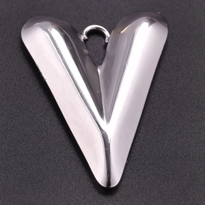 Macro detail of polished silver heart pendant in 304 stainless steel on black texture