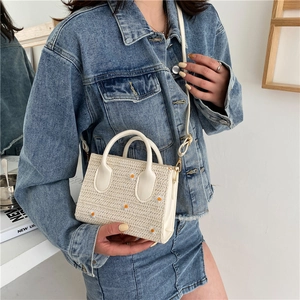 Handmade beige woven straw bag with white daisy embroidery and white leather handles