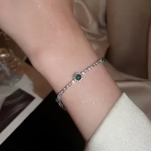 Bracelet élégant avec pierre précieuse vert émeraude et zircons étincelants sur le poignet