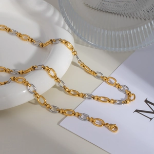 Détail d'un collier bicolore à maillons ovales avec fermoir mousqueton sur céramique