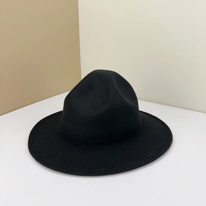 Detailed texture of a classic black wool felt fedora hat with a wide brim on minimalist background