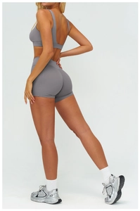 Vista posteriore del set yoga grigio con pantaloncini a vita alta e reggiseno sportivo