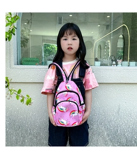 Primer plano de mini mochila rosa para niñas con estampados de unicornios y arcoíris