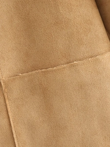 Detailed macro view of camel suede fabric texture with professional stitched seam lines
