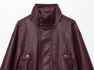 Close-up of burgundy PU leather jacket detailing stand collar and metallic buttons