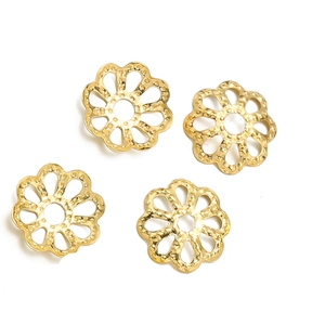 Macro shot of gold floral metal spacer beads with textured finish for DIY jewelry crafting