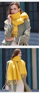 Detail of soft yellow double-sided scarf featuring stylish fringe and warm cashmere texture