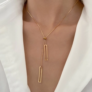 Close-up of geometric pull-out gold Y-shaped necklace with hollow rectangular pendants