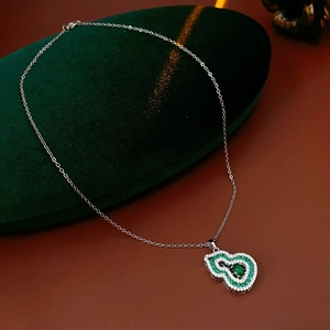 Macro detail of wulu pendant necklace with green emerald zircon and white crystals