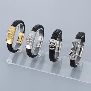 Braided leather bracelets for men with gold lion and skull charms on display stand