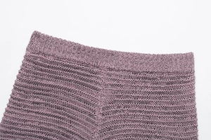 Detail view of purple knitted shorts featuring a comfortable elastic waistband and texture