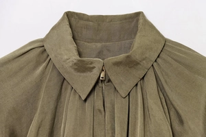 Detail of army green bomber jacket featuring a turn-down collar and premium metal zipper