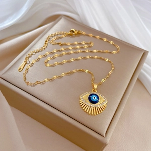 Detailed macro view of gold evil eye pendant with blue crystals on white silk
