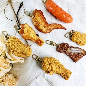 Detail of realistic fried chicken and sausage keychains with gold lobster clasps