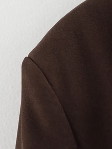 Close-up of deep brown high-density twill fabric on a fashion blazer shoulder