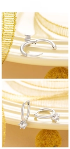 Detail showing the snap closure and four-prong round zircon setting on silver hoop earrings