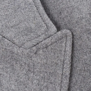 Close-up detail of grey tweed jacket collar showcasing premium fabric weave and stitching