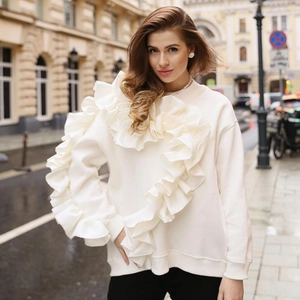 Sweat-shirt blanc à manches longues avec volants superposés dans une rue de la ville