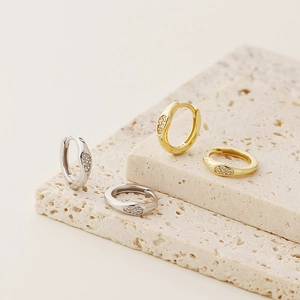 Detailed shot of gold and silver S925 sterling silver earrings set with sparkling zircons