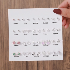 Lot de 12 paires de boucles d'oreilles argentées avec perles sur une carte à bijoux