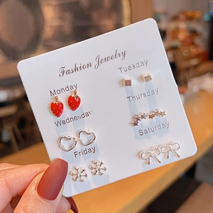 Close-up of 6 pairs of colorful stud earrings on a weekly card from Monday to Saturday