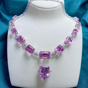 Detail of emerald-cut pink gemstone necklace with brilliant diamond halo accents
