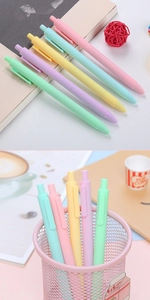 Macro view of macaron colored retractable gel pens in a pink mesh pen holder
