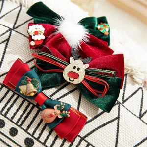 Detail of Christmas hair clips featuring velvet bows, Santa, and reindeer figures