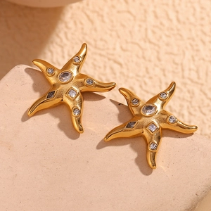 Detail of 18K gold-plated starfish stud earrings with sparkling crystals on stone