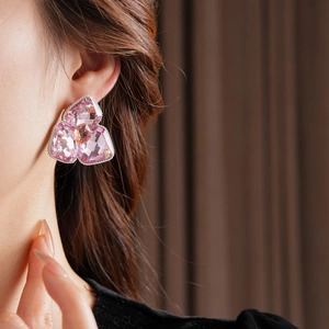 Macro shot of large pink crystal flower earring with intricate metal inlay detail