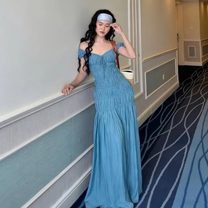 Détail d'une robe bleue à épaules dénudées avec poitrine plissée et tissu texturé