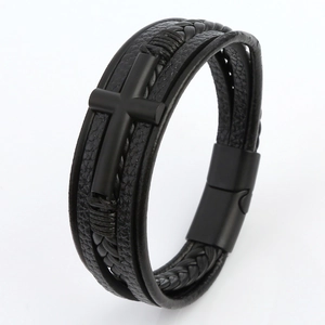 Close-up of layered black leather bracelet featuring a metal cross and magnetic clasp