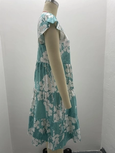 Detail view of teal floral dress featuring ruffled flutter sleeves and layered tier design
